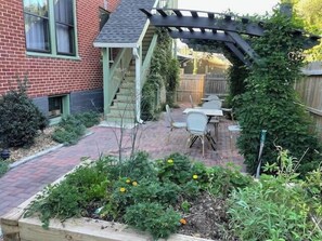 Une maison en briques avec un patio, une terrasse en bois et une pergola.
