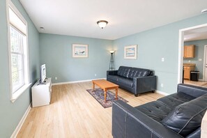 Ein Wohnzimmer mit einer Couch, einem Couchtisch und einer TV-Kommode.