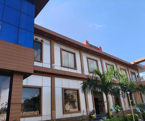 Un edificio de varios pisos con un diseño arquitectónico moderno, que cuenta con amplios ventanales y un techo plano.
