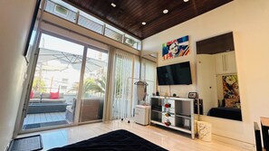 A modern bedroom with a large bed, a TV mounted on the wall, and a balcony with a view of the city. - Frida Kahlo private 1-bedroom loft  in vibrant Houston (Houston)