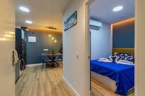 A compact room with a bed, a small dining area, and a kitchenette. - Appartement 2 chambres moderne et calme - Marqués Vadillo (Madrid)