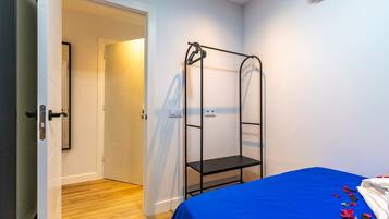 Una habitación con literas, una puerta que da a otra habitación y una mesita pequeña.