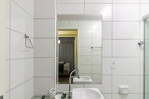 A bathroom with white tiles, a mirror, a sink, and a shower area. - Apt. in Condo. w/ BBQ nr. 287m Beach Rcl0104 (Itapema)