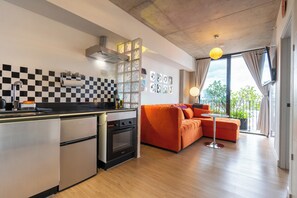 A modern kitchen with a built-in oven and a compact refrigerator.