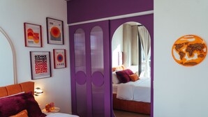 Ein Schlafzimmer mit einem Bett, einem Spiegel und Kunstwerken an der Wand.