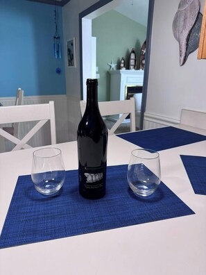 Ein Esstisch mit einer Flasche und zwei Gläsern auf einer blauen Tischmatte.