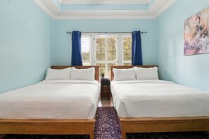 A room with two beds, a window with curtains, a painting on the wall, and a patterned rug. - Hot Tub · Estate on the RTJ Fairway · Sleeps 16+ (Bessemer)