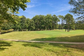 A golf course with a well-maintained fairway, trees lining the perimeter, and a clear sky. - Hot Tub · Estate on the RTJ Fairway · Sleeps 16+ (Bessemer)