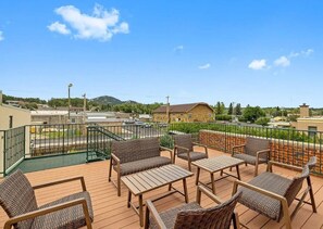 Eine Terrasse mit Korbmöbeln und einem Pool.