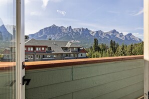 A residential building with a view of mountains. - Mountain Views | Outdoor Heated Pool | Hot Tub (Canmore)