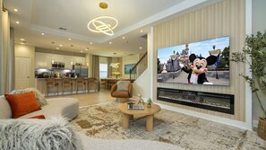 Un salon moderne doté d’un téléviseur à écran plat, d’une cheminée et d’un coin salon confortable.