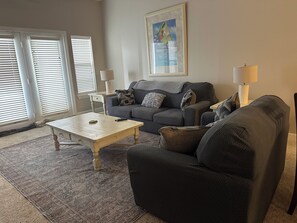 A living room with a sofa, a coffee table, and a lamp.