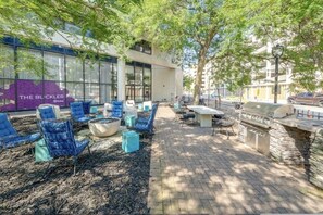 An outdoor seating area with blue chairs and a stone barbecue.