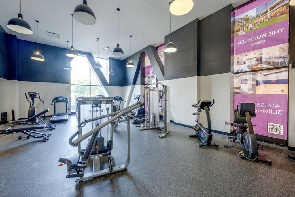 A gym with various exercise equipment, including treadmills, elliptical machines, and weight machines.