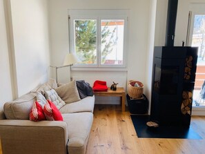 Uma sala de estar acolhedora, com sofá, mesa, abajur e lareira.