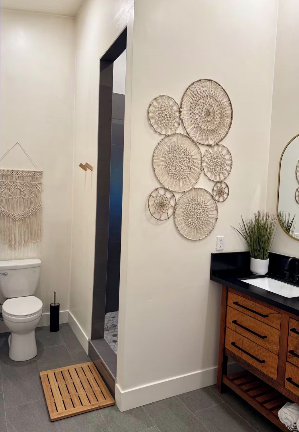 Ein modernes Badezimmer mit Toilette, Waschbecken, Waschtisch und dekorativer Wandgestaltung.