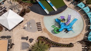 An aerial view of a water park with a central water slide, surrounding lounge areas, and a pool. - 4BR Themed Villa Pool & Cinema Balmoral Resort (Haines City)