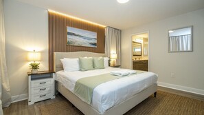 A hotel room with a large bed, bedside tables, a mirror, and a painting on the wall. - 4BR Themed Villa Pool & Cinema Balmoral Resort (Haines City)