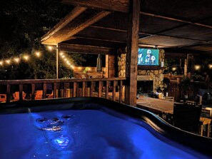 Ein Whirlpool mit Holzterrasse und Sitzgelegenheit im Freien.