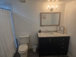 Ein Badezimmer mit Toilette, Waschbecken und Spiegel.
