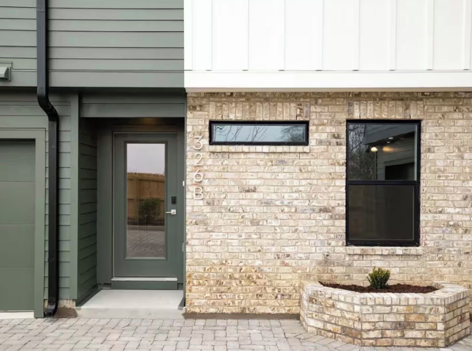 Un bâtiment avec une façade en briques, une porte et une fenêtre.