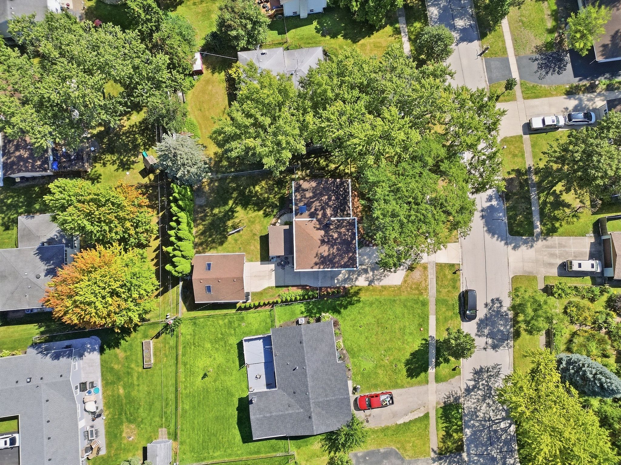 Vue aérienne d’un quartier résidentiel avec des maisons, des pelouses et une route.