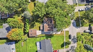 Vue aérienne d’un quartier résidentiel avec des maisons, des pelouses et une route.