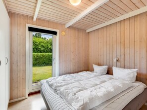 A bedroom with a bed, a window, and wooden walls. - "Tobias" - 30km from the sea by Interhome (Toftlund)