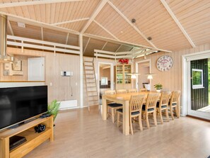A spacious room with a wooden dining table, chairs, a TV, and a clock on the wall. - "Tobias" - 30km from the sea by Interhome (Toftlund)