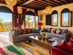 A spacious living area with a sofa set, a coffee table, and a view of the outdoors.