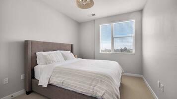 A bedroom with a bed, a window, and a ceiling fan.