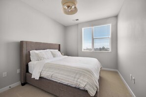 Ein Schlafzimmer mit einem Bett, einem Fenster und einem Deckenventilator.