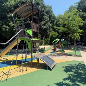 A playground with a slide, climbing structures, and a small playhouse. - Stylish Studio in the Heart of Cannes – Central Location & Contemporary Comfort” (Cannes)