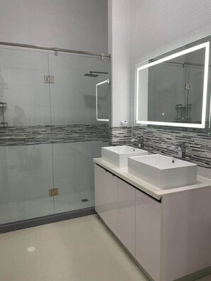 A modern bathroom with a glass shower enclosure, a large mirror, and two sinks. - Celebrity Lifestyle / Dream36 Montego bay Jamaica (Montego Bay)