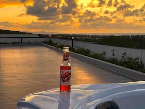 A bottle of Sorrento on a rooftop with a sunset view. - Celebrity Lifestyle / Dream36 Montego bay Jamaica (Montego Bay)