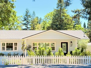 A single-story house with a white picket fence, a front porch, and a mailbox. - Bluebird Bungalow- Renovated Mid-Century Dream in the Historic Core of J-Ville! (Jacksonville)