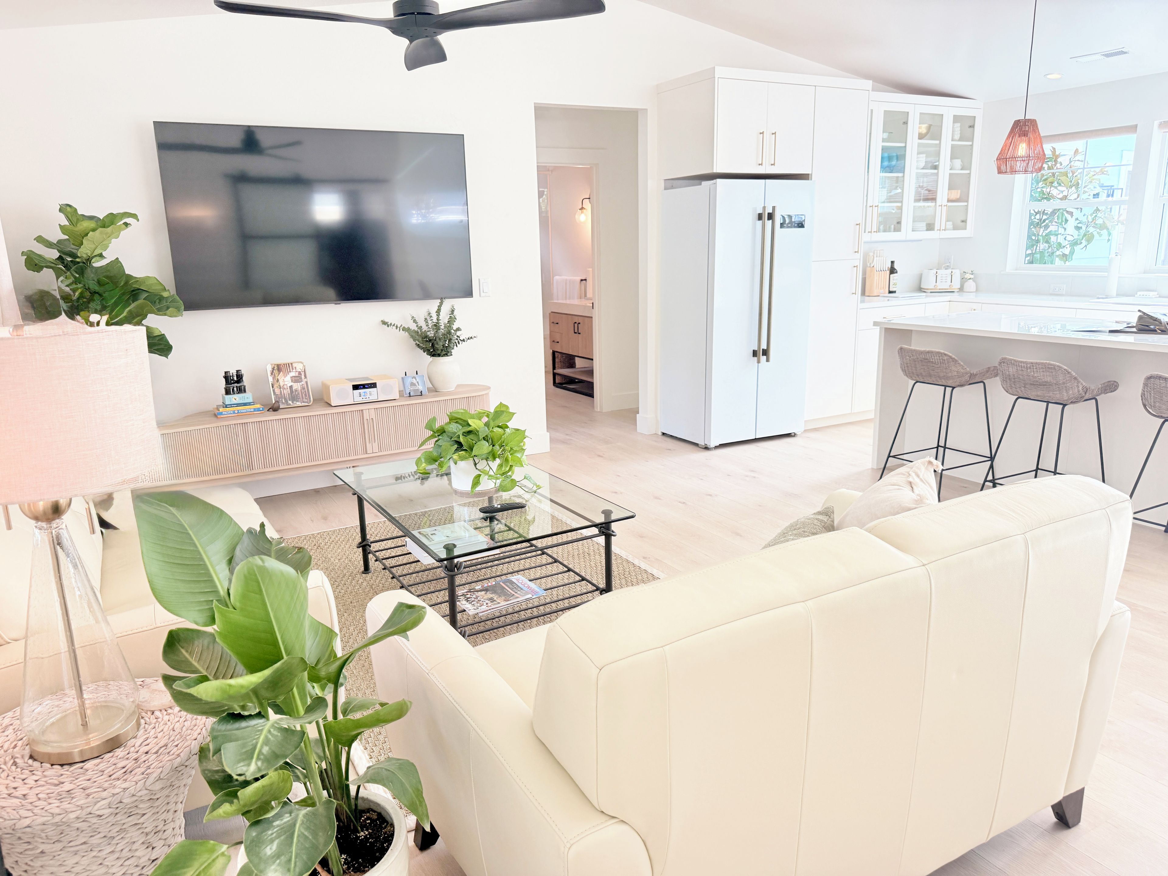 A modern living room with a sofa, coffee table, and potted plants.
