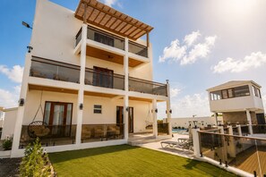 A multi-story residential building with balconies, a swimming pool, and a separate structure with a roof. - Villa Camila Unit 1: Modern, Central Villa with Tranquil Charm (Cooper Jack Bay Settlement)