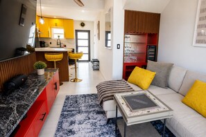 A modern living room with a sofa, a coffee table, and a board game. - Villa Camila Unit 1: Modern, Central Villa with Tranquil Charm (Cooper Jack Bay Settlement)