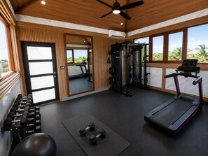 A gym with a treadmill, weight bench, dumbbells, and a squat rack. - Villa Camila Unit 1: Modern, Central Villa with Tranquil Charm (Cooper Jack Bay Settlement)