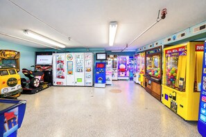 An indoor arcade with various gaming machines, including a yellow 'Win Win Win' game and a 'Turtles' ride-on vehicle. - Golden Sands 1611111 (Ocean City)
