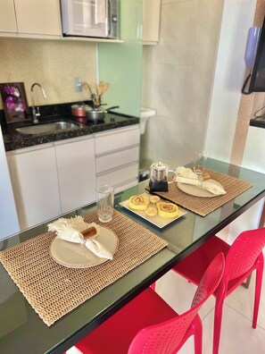 A dining table with placemats, plates, and a glass of water. - Cozy 1-bedroom apartment with AC in beautiful São Luís (São Luís)