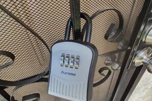 A security keypad with the brand name 'Puroma' on a metal mesh surface. - Cozy Private Casita Near RUHS with Full Kitchen, Laundry and Parking (Moreno Valley)