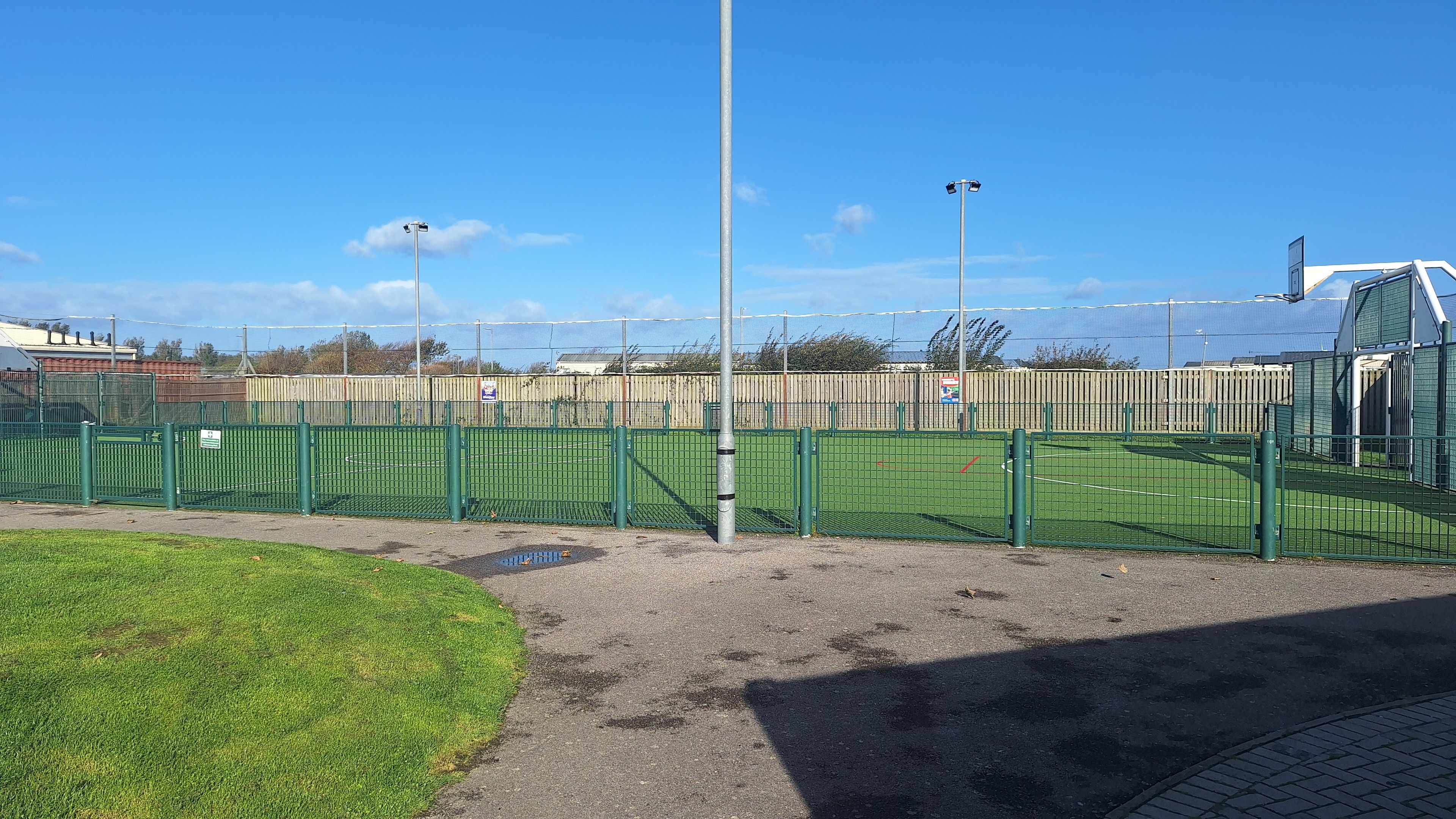 A fenced sports field with a clear sky.