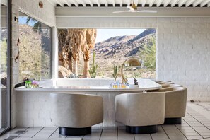 A modern bathroom with a large window, a bathtub, and two seating areas. - ZAINALAND!! Mythic Desert Den!! (Twentynine Palms)