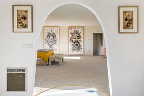 A room with a bed, a bench, and two framed artworks on the wall. - ZAINALAND!! Mythic Desert Den!! (Twentynine Palms)