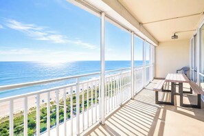 Ein Balkon mit Blick auf den Ozean, einem Tisch und Stühlen.