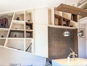 A modern interior with a built-in shelving unit displaying various decorative items. - Borgo dei Fiori by Interhome (Magliolo)