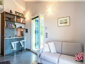 A modern living room with a sofa, a coffee table, and a bookshelf. - Borgo dei Fiori by Interhome (Magliolo)