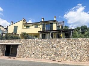 A two-story building with a stone wall facade, a balcony, and a covered entrance. - Borgo dei Fiori by Interhome (Magliolo)